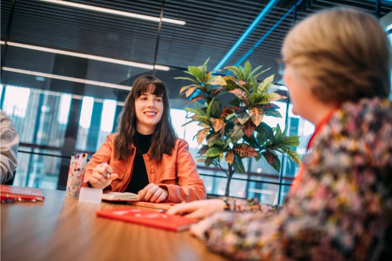 student sitting talking to university staff